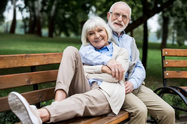 Feliz casal sênior descansando no grupo de madeira no parque — Fotografia de Stock