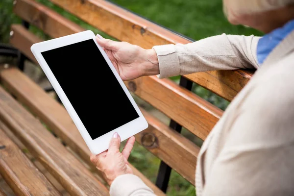 Селективный фокус цифрового планшета с чистым экраном в руках пожилой женщины — стоковое фото