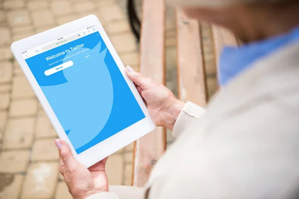 Selective focus of senior woman using digital table with twitter upp on screen — Stock Photo