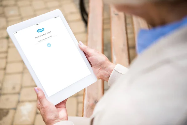 Selective focus of senior woman using digital tablet with skype app on screen — Stock Photo