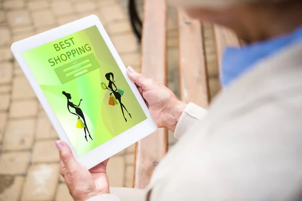 Enfoque selectivo de la mujer mayor utilizando portátil digital con compras en línea en la pantalla - foto de stock