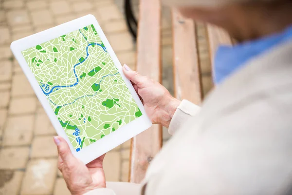 Selective focus of senior woman using digital tablet with map on screen — Stock Photo