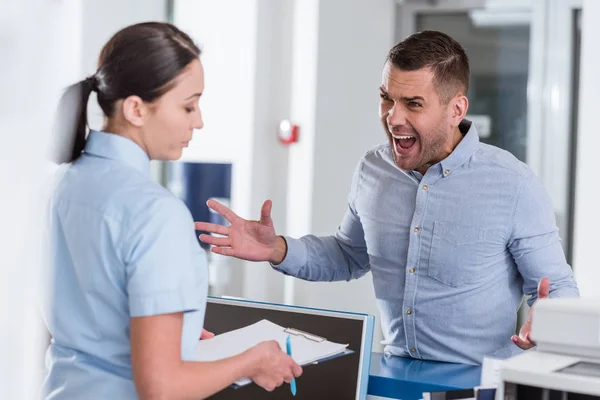 Aggressiver Mann brüllt Krankenschwester in Klinik an — Stockfoto