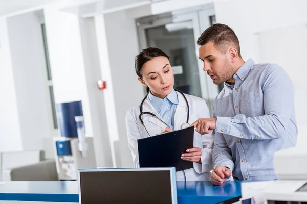 Doctor talking to patient about diagnosis in clinic — Stock Photo