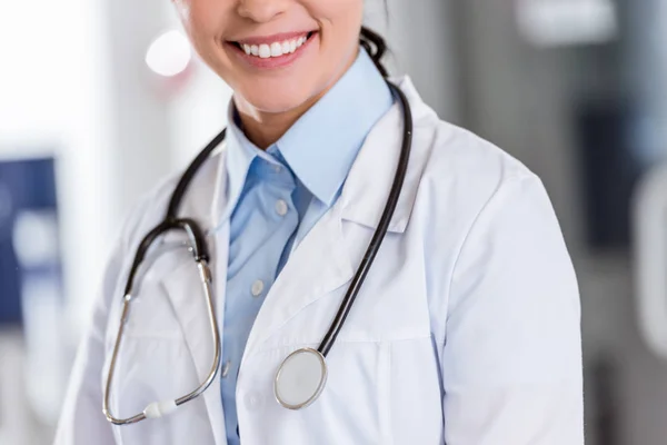 Cropped view of smiling female doctor with stethoscope — Stock Photo