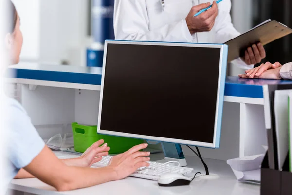 Vista recortada de la enfermera y el médico hablando en la clínica - foto de stock