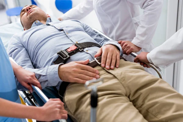 Unconscious patient lying on gurney in clinic — Stock Photo