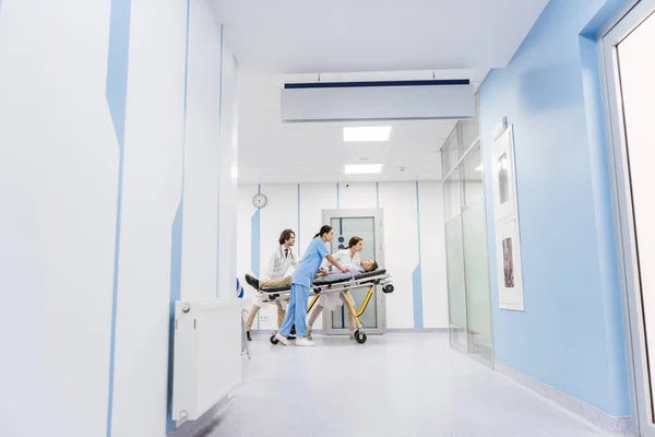 Полный обзор врачей и медсестер, перевозящих пациента без сознания — стоковое фото
