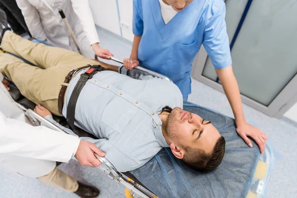 Vue recadrée des médecins transportant le patient sur le brancard — Photo de stock