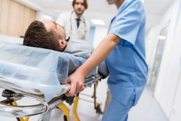 Vue recadrée des médecins transportant le patient sur le brancard — Photo de stock