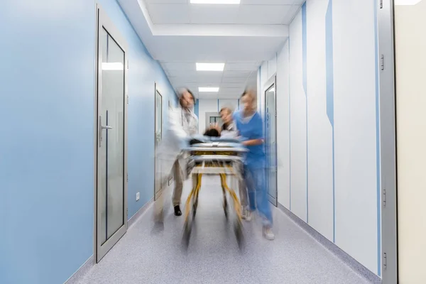 Groupe de médecins transportant le patient sur le brancard — Photo de stock