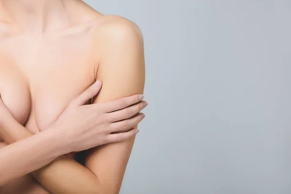 Vue partielle de la fille nue couvrant le sein, isolé sur gris — Photo de stock