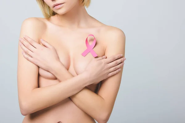 Cropped view of naked girl with pink breast cancer awareness ribbon, isolated on grey — Stock Photo