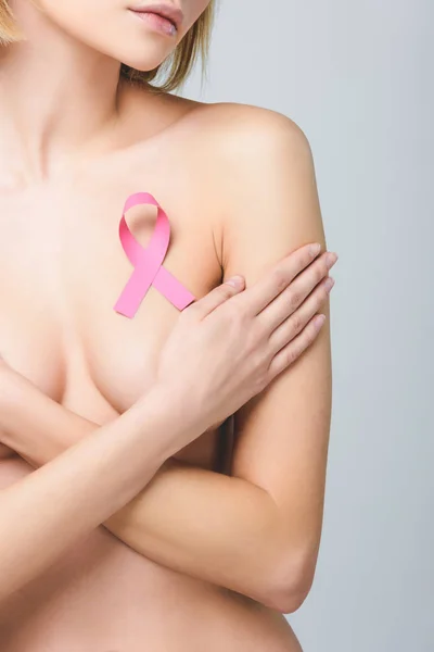 Cropped view of nude girl with pink breast cancer awareness ribbon, isolated on grey — Stock Photo