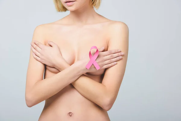 Cropped view of young nude woman with pink breast cancer awareness ribbon, isolated on grey — Stock Photo