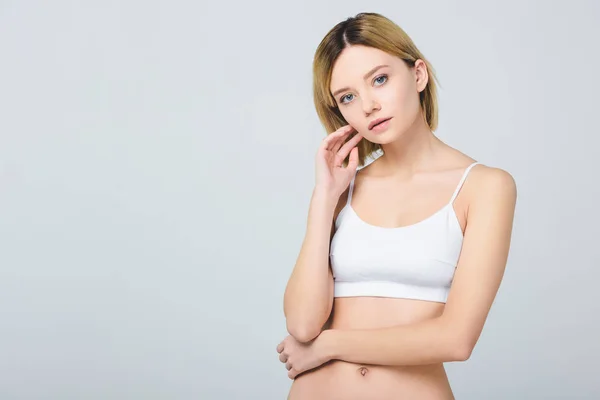 Attractive young woman posing in white bra isolated on grey — Stock Photo