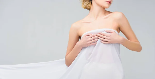 Обрізаний вид на голу дівчину, що позує в елегантній білій завісі, ізольовано на сірому — стокове фото