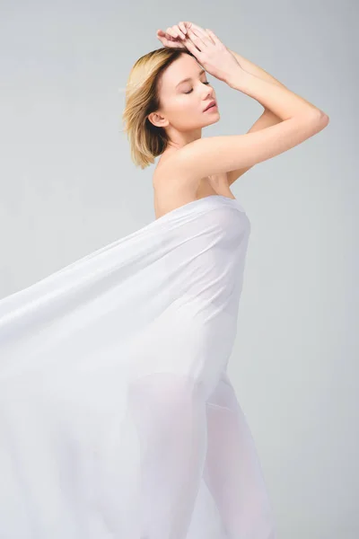 Ніжна гола дівчина позує в елегантній білій вуаль, ізольована на сірому — стокове фото