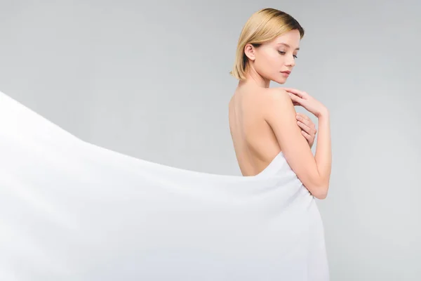 Naked tender girl posing in elegant white cloth, isolated on grey — Stock Photo