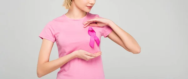 Vue recadrée de fille posant en t-shirt rose avec ruban de sensibilisation au cancer du sein, isolé sur gris — Photo de stock