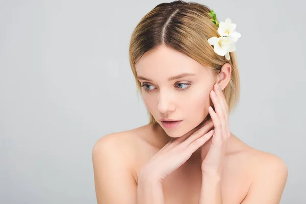 Schöne zarte Mädchen mit sauberem Gesicht und Freesia-Blumen im Haar, isoliert auf grau — Stockfoto