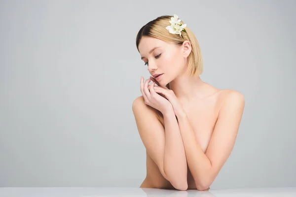 Attraktives blondes Mädchen posiert mit Freesia-Blumen im Haar, isoliert auf grau — Stockfoto