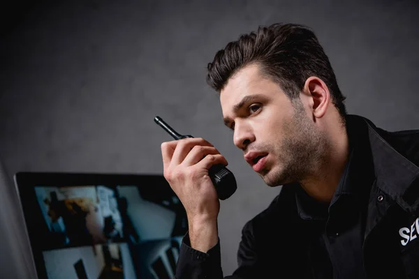 Guard in uniform talking on walkie-talkie at workplace — Stock Photo