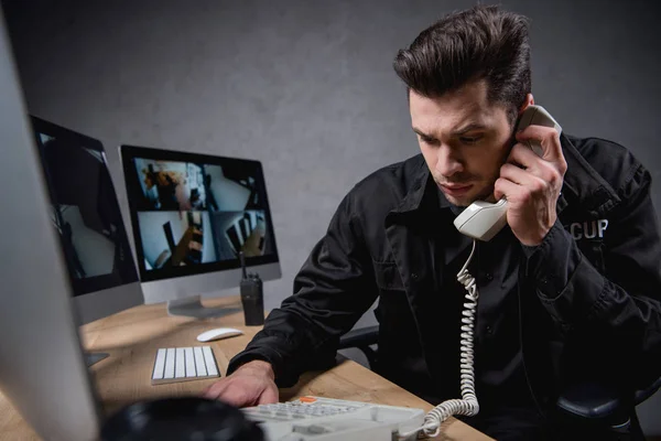 Worried guard in uniform talking on telephone — Stock Photo