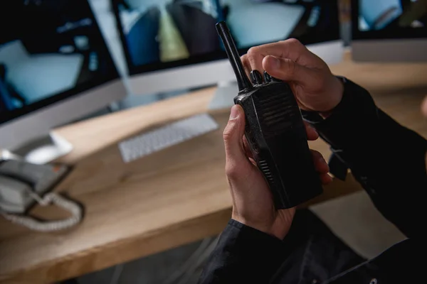 Vista ritagliata della protezione che tiene walkie-talkie sullo spazio di lavoro — Foto stock