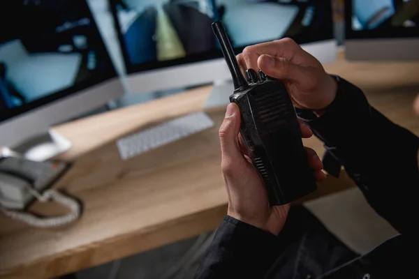 Vista recortada del guardia sosteniendo walkie-talkie en el espacio de trabajo - foto de stock