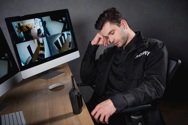 Handsome guard in uniform sleeping at workplace — Stock Photo
