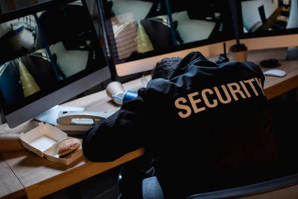 Selective focus of guard sleeping in uniform at workspace — Stock Photo