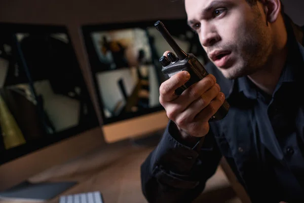 Selective focus of guard in uniform talking on walkie-talkie at workplace — Stock Photo