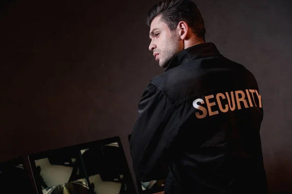 Rückansicht der Wache in schwarzer Uniform am Arbeitsplatz — Stockfoto