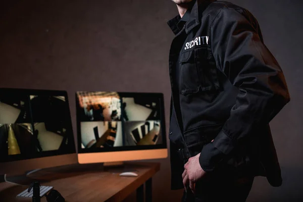 Vista ritagliata di guardia in uniforme nera sul posto di lavoro — Foto stock