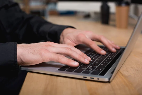 Partial view of guard using smartphone and laptop — Stock Photo