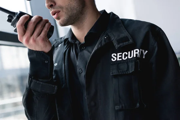 Corte vista de guarda em uniforme falando em walkie-talkie — Fotografia de Stock