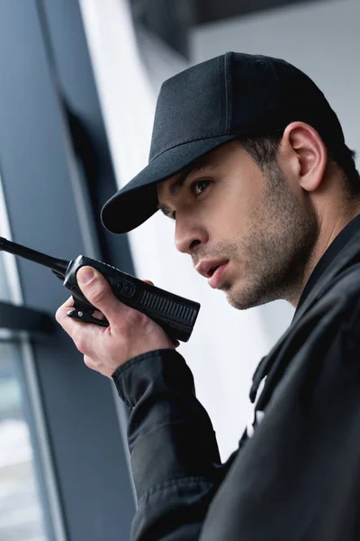 Close up of guard in black uniform using walkie-talkie — Stock Photo