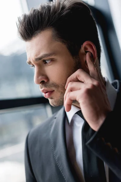 Close up of handsome bodyguard using earphone — Stock Photo