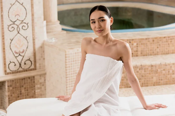 Atractiva mujer asiática en toalla relajante y descansando en spa - foto de stock