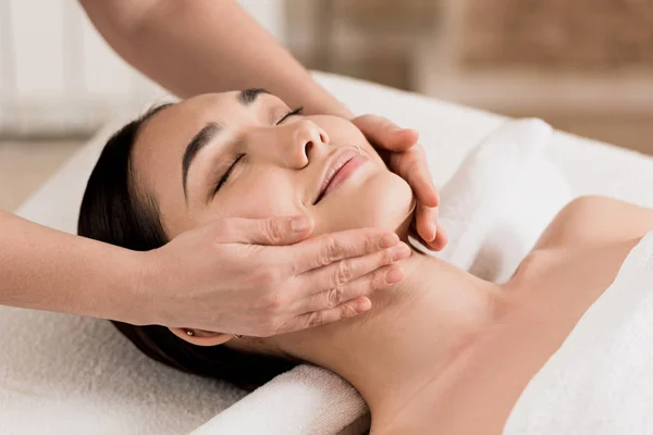 Frau bekommt Gesichtsmassage mit geschlossenen Augen im Spa — Stockfoto