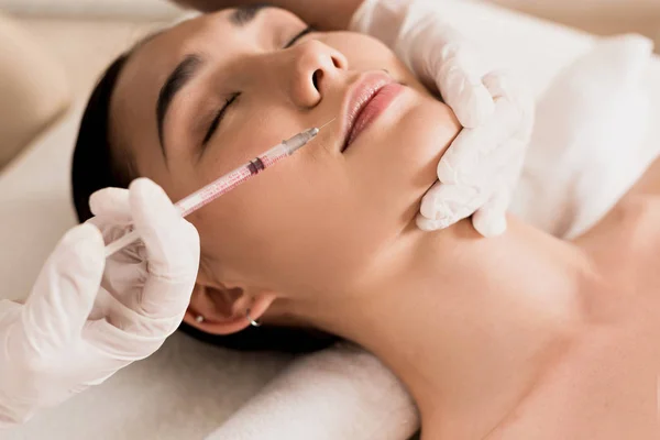 Close up of attractive asian woman getting beauty injection at clinic — Stock Photo