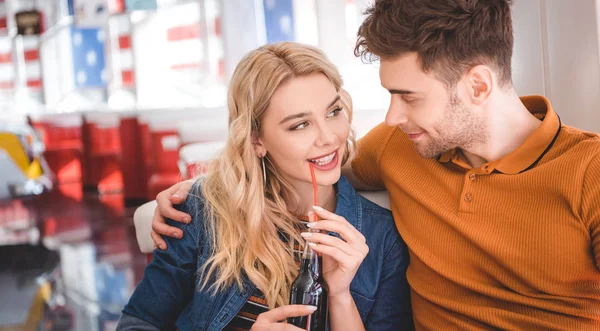 Beautiful woman holding glass bottle with soda and hugging with handsome man — Stock Photo