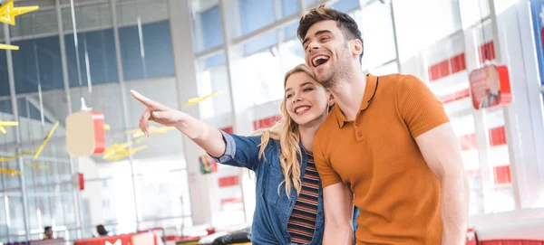 Beau couple souriant, regardant loin et étreignant au café — Photo de stock