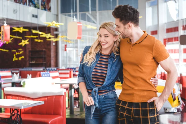 Beautiful woman and handsome man looking away and hugging at cafe — Stock Photo