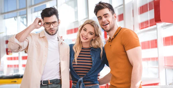 Smiling beautiful and handsome friends hugging and looking at camera — Stock Photo