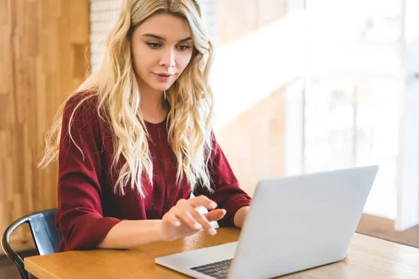 Beautiful and attractive woman using laptop at cafe with copy space — Stock Photo