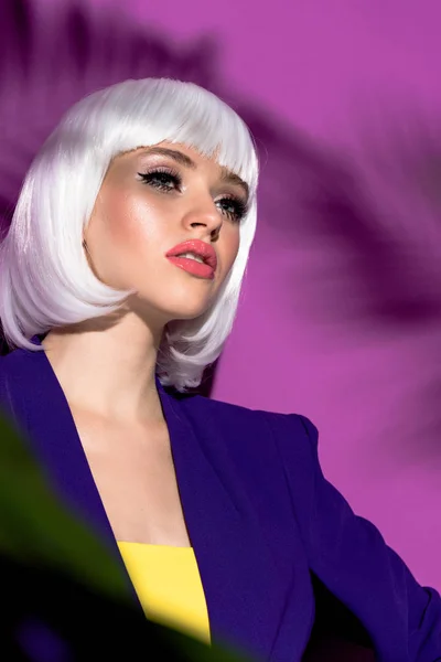 Мечтательная девушка в белом парике смотрит в сторону на фиолетовом фоне — стоковое фото