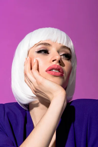Chica pensativa con cara de apoyo de maquillaje de moda con la mano aislada en púrpura - foto de stock