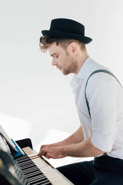 Pianista concentrado en ropa elegante tocando el piano - foto de stock